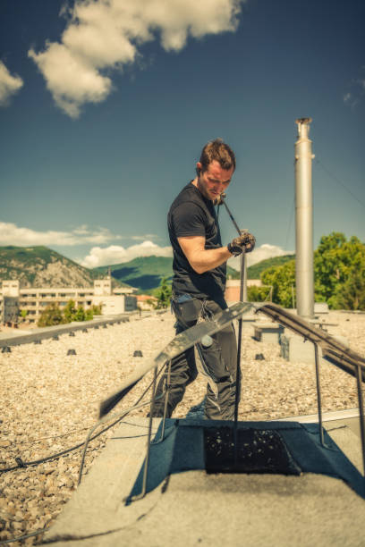 Chimney sweeper cleaning a chimney on top of the roof