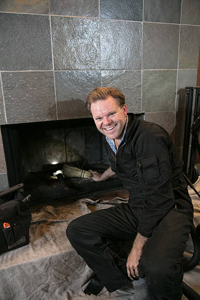 Chimney Sweep cleaning fireplace inside of home